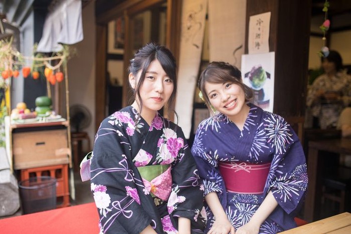 Kimono dan Yukata Sisters in Yukata sitting at terrace of Japanese traditional cafe