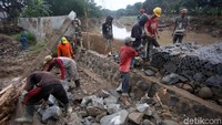 Sejumlah pekerja bahu membahu memperbaiki tanggul Kali Bekasi yang jebol di kawasan Perumahan Pondok Mitra Lestari, Bekasi, Jawa Barat, Kamis (9/1/2020).