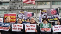 Para demonstran anti-perang membawa poster berisi kecaman dan menolak perang usai aksi saling serang antara AS dan Iran berlangsung di Timur Tengah. Getty Images/Chung Sung-Jun.