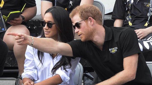 FILE - In this Monday, Sept. 25, 2017 file photo Prince Harry and his then girlfriend Meghan Markle attend a wheelchair tennis event at the Invictus Games in Toronto. In a stunning declaration, Britain's Prince Harry and his wife, Meghan, said they are planning 
