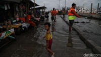 Seorang anak terlihat bermain di tengah rob di kawasan pelabuhan.