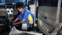 Seorang mekanik melepas dashboard yang akan dibersihkan.