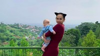 Mengenakan bando cat ear, penyanyi seksi ini berpose sadar kamera. Namun bayinya menoleh ke arah lain. Liha apa sih Arabella? (aurakasih/Instagram)