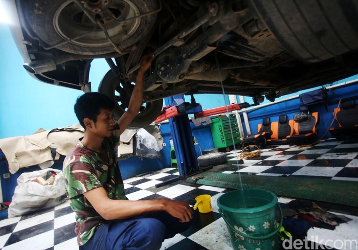 Montir memperbaiki mobil yang sempat terendam banjir, di bengkel mobil Sapta Jati Asih, Bekasi, Jawa Barat, Kamis (9/1/2020). Sebanyak 25 mobil yang terendam banjir diperbaiki di sini dengan biaya mulai Rp 2 juta hingga Rp 10 juta tergantung jenis kerusakan dan penggantian komponen.