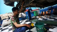 Mekanik mengecek kolong mobil yang sebelumnya terendam banjir. Selain itu dia juga membersihkan tangki BBM.