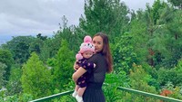 Dengan latar hijau-hijau, netizen dibuat menebak-nebak kemana hot mom ini menikmati waktu bersama anaknya. (aurakasih/Instagram)