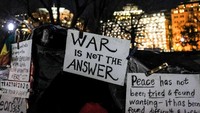 Para demonstran membawa berbagai poster berisi kecaman dan penolakan aksi saling serang yang dilakukan Amerika Serikat dan Iran di Timur Tengah. Getty Images/Alex Wroblewski.