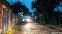 Sebuah mobil tampak melintas di samping mobil yang diparkir di pinggir jalan.