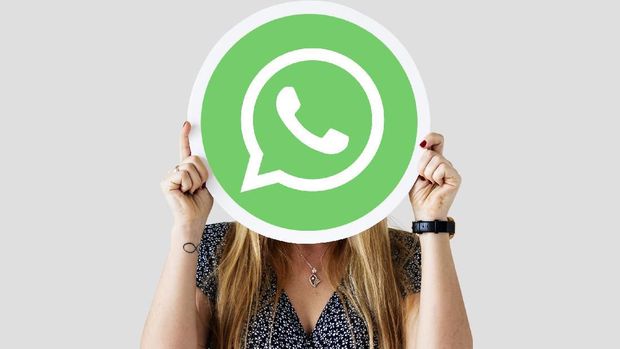 Woman showing a WhatsApp Messenger icon