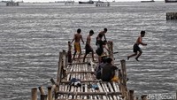 Meskipun demikian, Sejumlah anak-anak tetap asyik berenang sambil bermain di kawasan pantai utara Jakarta.