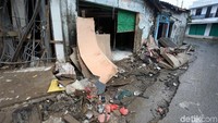 Kios-kios rusak dengan tumpukan sampah di depannya.
