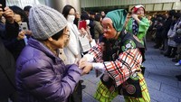 Salah satu seniman yang mengenakan topeng badut tradisional Jepang menyapa warga yang antusias menyaksikan penampilan para seniman itu dalam Festival Konpira.