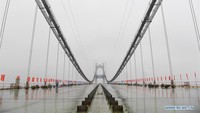 Ini adalah jembatan gantung pertama yang menjadi jalur jalan tol, kereta, hingga orang sekaligus. Foto: Dok. Xinhua/Li Bo