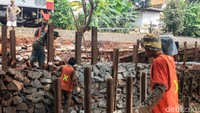 Anyaman bronjong yang telah dipasang di dinding jalur rel kereta api diisi dengan batu.