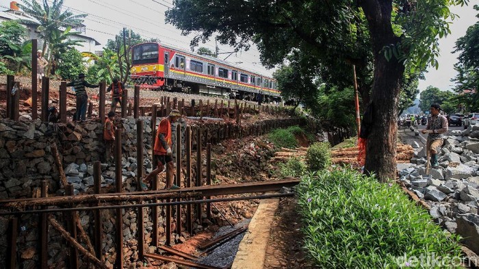 Para pekerja membuat bronjong untuk membangun pondasi anti longsor di pinggir rel kereta api, di Bintaro, Jakarta Selatan, Sabtu (11/1/2020). Jalur rel yang bersisian dengan sungai dan jalan tersebut berpotensi longsor karena terkikis air hujan.