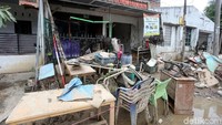 Sampah-sampah yang terkena banjir pun masih menumpuk di depan rumah-rumah warga.