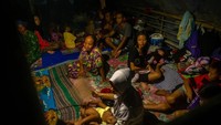 Sejumlah pengungsi korban banjir Sungai Tuntang beraktivitas di dalam tenda darurat yang mereka dirikan di atas tanggul Desa Trimulyo, Guntur, Kabupaten Demak, Jawa Tengah, pada Minggu (12/1) malam.