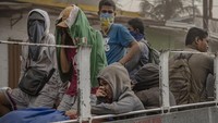 Warga menutupi hidung mereka dengan menggunakan masker maupun kain dan tangan agar tak menghirup abu vulkanik saat sedang menuju ke pengungsian.