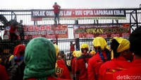 Sejumlah demonstran memasang spanduk berisi penolakan terhadap Omnibus Law-RUU Cipta Lapangan kerja di pintu gerbang gedung DPR.