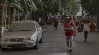 Warga pun menggunakan berbagai benda mulai dari payung, kain, hingga kardus untuk menutupi diri mereka dari abu saat beraktivitas di luar ruangan.