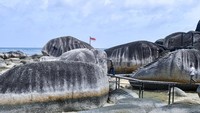 Bendera merah putih berkibar di antara tumpukan Alif Stone Park di Natuna, Kepulauan Riau.