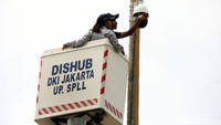 Dua orang petugas Dishub memperbaiki CCTV di Jalan Menteng Raya, Senin (13/1/2020)