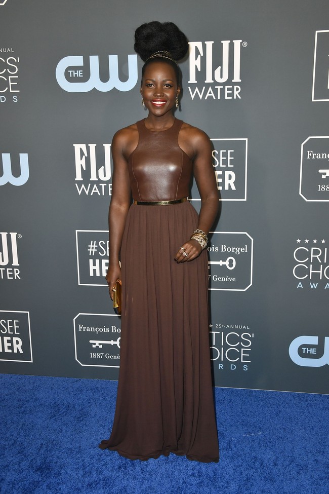 Lupita Nyongo bak ratu Afrika yang edgy dengan gaun kulit beraksen emas dari Michael Kors ini. (Foto: Frazer Harrison/Getty Images)