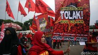 Seorang demonstran membawa poster yang berisi penolakan terhadap Omnibus Law.