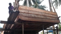 Pekerja tengah memaku kayu untuk bodi kapal.