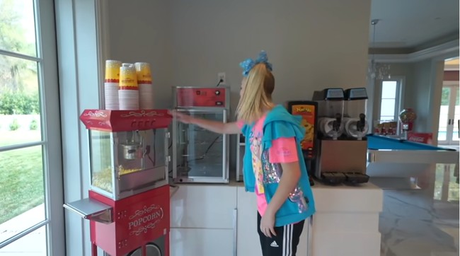 Dengan adanya mesin pembuat popcorn, gula-gula kapas hingga nachos, artis remaja yang dikenal lewat acara Dance Moms ini tidak perlu repot-repot keluar rumah saat ingin jajan, karena semuanya sudah tersedia di tempat tinggalnya. Foto: Screenshot YouTube/ Its Jojo Siwa
