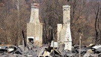 Dua buah perapian nampak berdiri di antara puing-puing bangunan yang hancur tak bersisa usai terbakar si jago merah. AP Photo/Rick Rycroft.