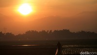 Selain menggarap sawah, ada juga petani yang berjalan di pematang untuk bergegas bekerja ke lahan garapannya.