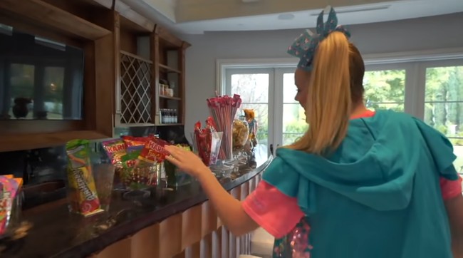 Bar khusus untuk permen dan makanan manis tersedia di area ini. Berbagai jenis permen bisa dipilih sesuai keinginan Jojo Siwa, dan mungkin juga teman-teman seumurannya yang berkunjung ke rumah. Foto: Screenshot YouTube/ Its Jojo Siwa
