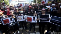 Mayoritas massa kontra Anies Baswedan mengenakan setelan hitam-hitam dengan atribut pin maupun ikat kepala kain merah putih.