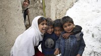 Keceriaan terlihat di wajah anak-anak Afghanistan saat bermain salju bersama-sama, Minggu (12/1) lalu.  AP Photo/Rahmat Gul.