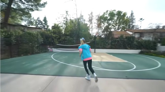 Halaman belakang dilengkapi lapangan basket yang juga bisa difungsikan sebagai lapangan tenis. Foto: Screenshot YouTube/ Its Jojo Siwa