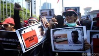 Massa kontra Gubernur DKI Jakarta membawa poster mengkritik Anies Baswedan saat menggelar aksi unjuk rasa di Balai Kota Jakarta, Selasa (14/1/2020).