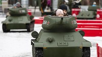 Seorang anak didampingi orang tuanya menjajal kendaraan tempur legendaris di era Soviet yang menjadi salah satu objek wisata petualangan anak-anak populer di Taman Sokolniki, Moskow, Rusia. AP Photo/Alexander Zemlianichenko.