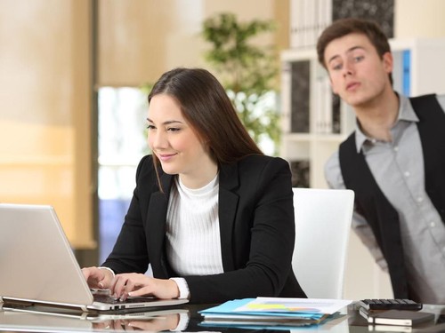 Front view portrait of a happy couple with perfect smile looking at you sititng on a couch in the living room at home in winter