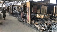 Seorang pasukan militer melintas di bagian dalam pangkalan udara Ain al-Asad yang rusak berat usai dirudal Iran. AP Photo/Qassim Abdul-Zahra.