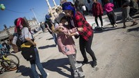 Seorang anak di Kota Gaza belajar bermain papan seluncur. Meski masih takut-takut, didampingi seorang wanita, anak tersebut berlatih menjaga keseimbangan saat bermain papan seluncur. AP Photo/Khalil Hamra.