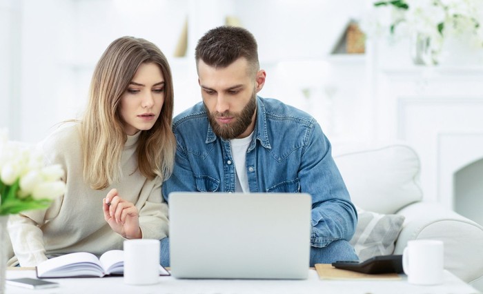 zodiak Confident couple trying to manage domestic finances, calculating and making notes