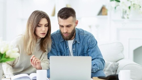 Confident couple trying to manage domestic finances, calculating and making notes