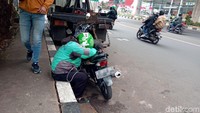 Seorang pengendara motor beristirahat sejenak di pinggir Jalan Tendean, Jakarta Selatan, Rabu (15/1/2020).