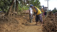Warga terpaksa menggunakan alat-alat sederhana saat membersihkan endapan lumpur dan tumpukan puing-puing yang menutupi jalan tersebut karena belum mendapat bantuan alat berat akibat jembatan menuju lokasi tersebut terputus akibat banjir bandang yang terjadi di awal tahun 2020 lalu. Antara Foto/Weli Ayu Rejeki.