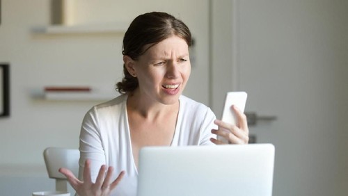 business woman feel depress and use smart phone while drinking coffee in the office