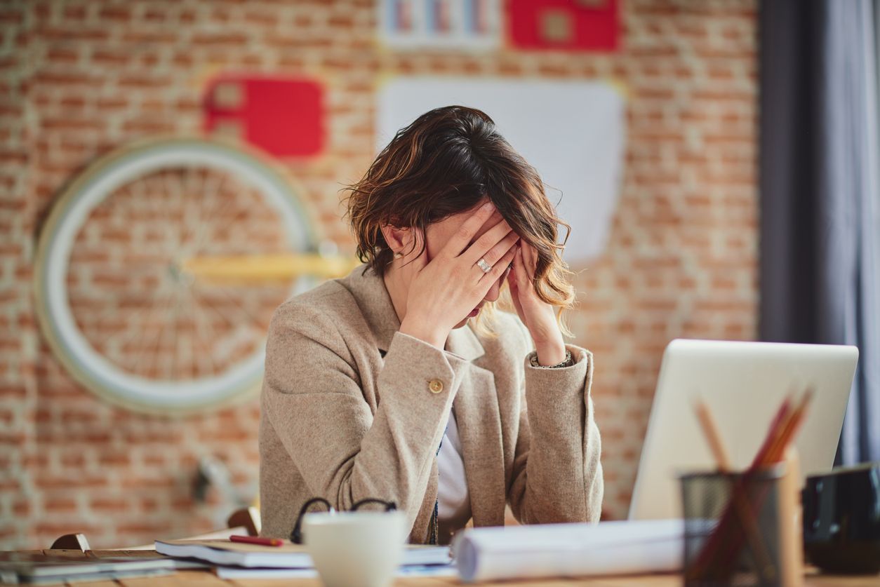 business woman feel depress and use smart phone while drinking coffee in the office