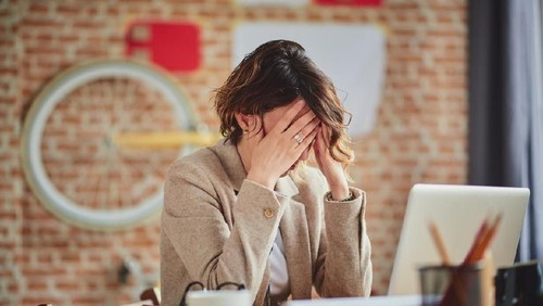 business woman feel depress and use smart phone while drinking coffee in the office