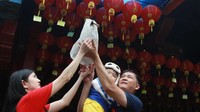 Satu keluarga etnis Tionghoa melakukan ritual Kias Pangsen atau pelepasan mahluk hidup di Vihara Boen San Bio, Tangerang, Banten, Kamis (16/1/2019). Ritual Pangsen merupakan ritual yang dilakukan jelang Tahun Baru Imlek, untuk mendapatkan keberuntungan dan kebahagiaan saat tahun baru. Antara Foto/Muhammad Iqbal.