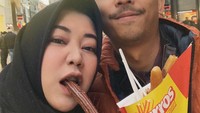 Jalan-jalan ke luar negeri bersama suami, wanita berhijab ini membagikan momen mesra mereka saat menyantap churros rasa cokelat. Foto: Instagram @risa_saraswati